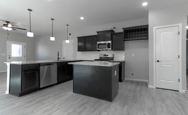 Open kitchen with island, dark cabinets, and stainless appliances