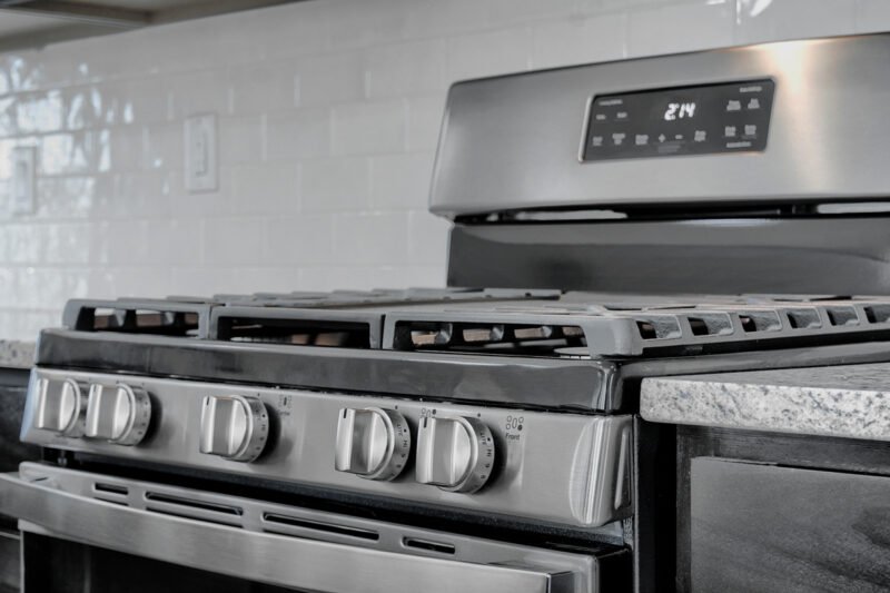 Kitchen stove and range hood with tile backsplash
