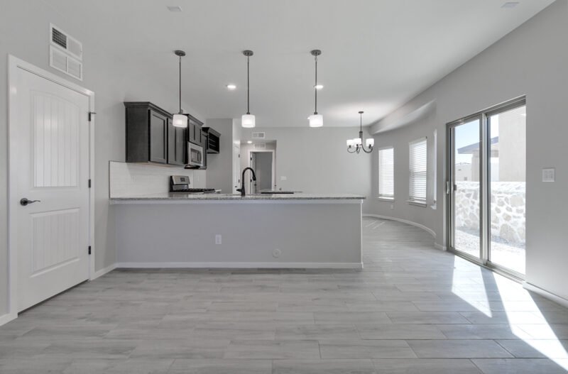 Open plan living room and kitchen with island and sliding glass door