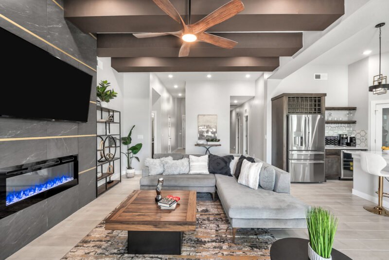 Open living room and kitchen in new home with gray sectional and fireplace