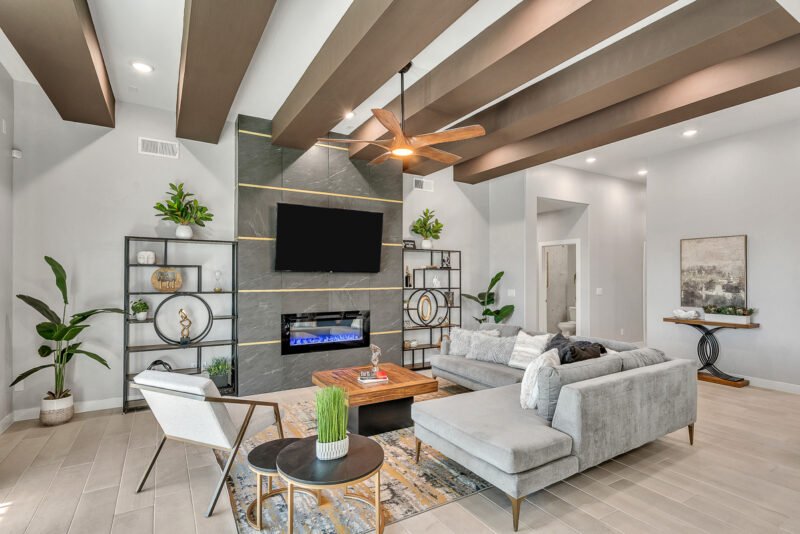 Stylish living room with sectional sofa, modern fireplace wall and ceiling beams