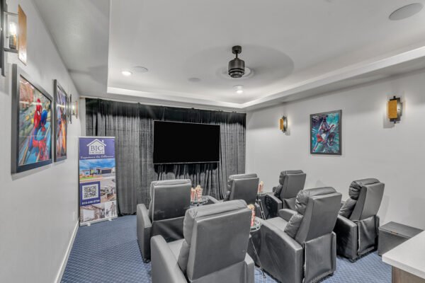 Home theater room with recliner seats and a large screen