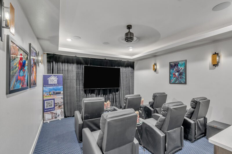 Home theater room with recliner seats and a large screen