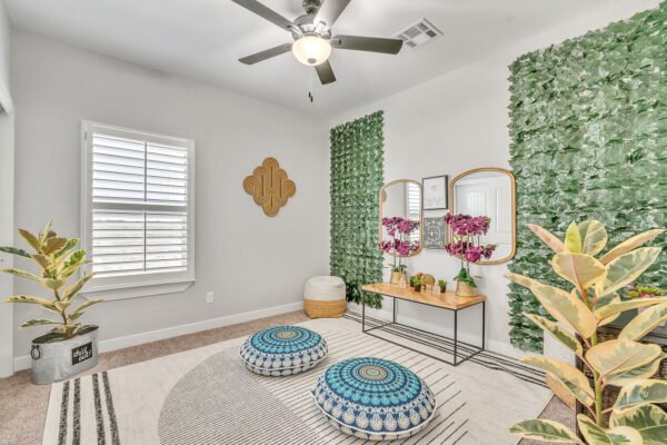 Bright sitting room with green plant wall, low cushions and console table