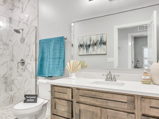 Bathroom with wood vanity, mirror, and walk‑in shower