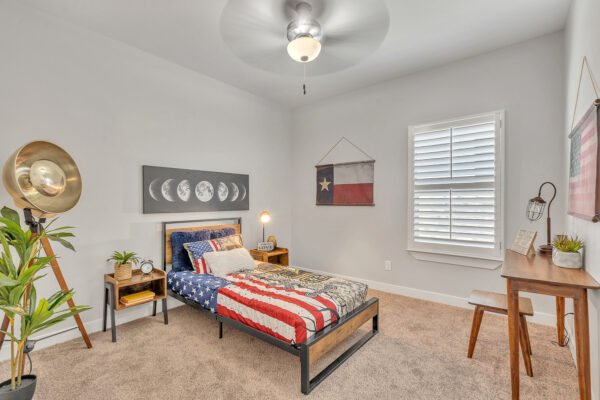 Bedroom with twin bed, Texas flag wall art, and desk