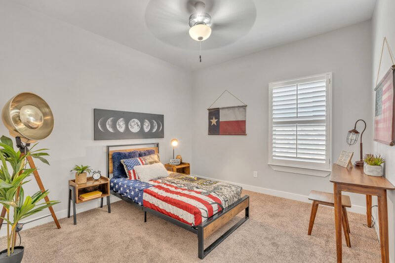 Bedroom with twin bed, Texas flag wall art, and desk