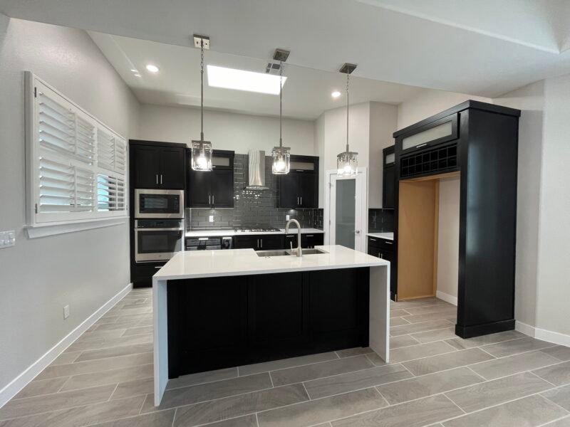 Kitchen with island, dark cabinets, and hanging lights