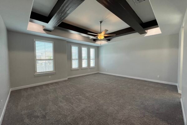 bedroom with ceiling beams and fan