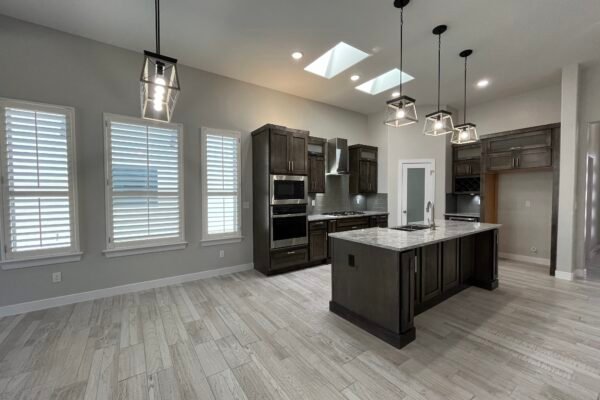 Modern kitchen with large island, dark wood cabinets, and skylights