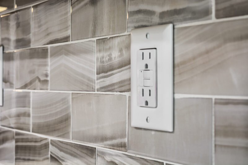 kitchen backsplash tile pattern with a white electrical outlet
