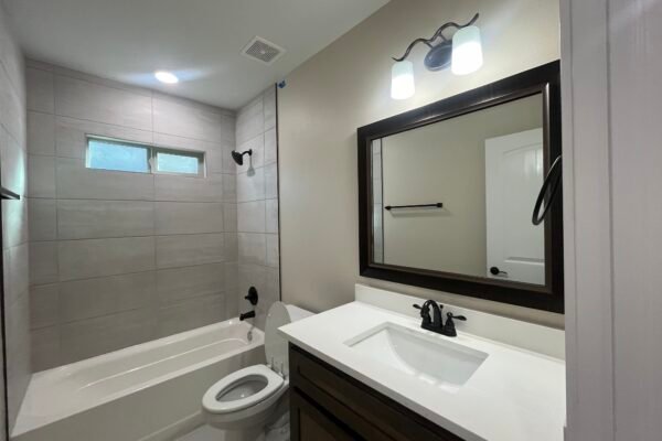 Bathroom interior with vanity, mirror, and tub
