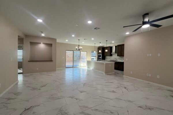 Open living space with kitchen island, tile floor, and ceiling fan
