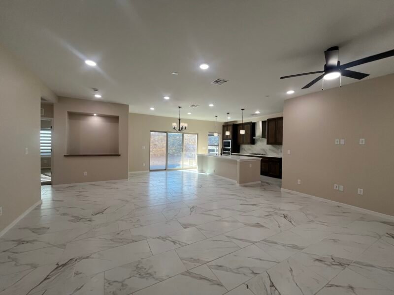 Open living space with kitchen island, tile floor, and ceiling fan