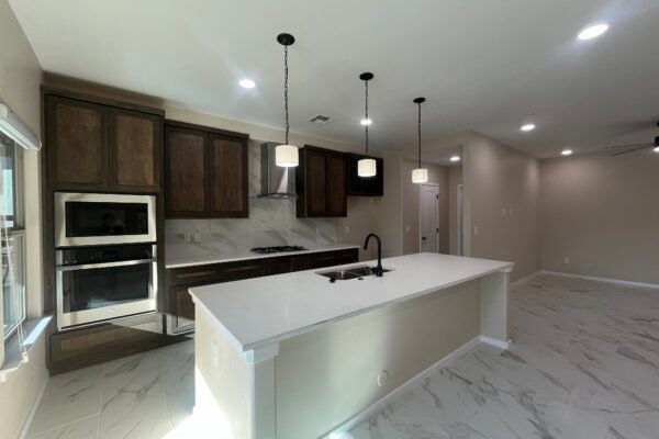 Open living area with kitchen island, cabinets, and tile floor