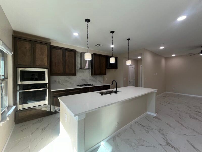 Open living area with kitchen island, cabinets, and tile floor