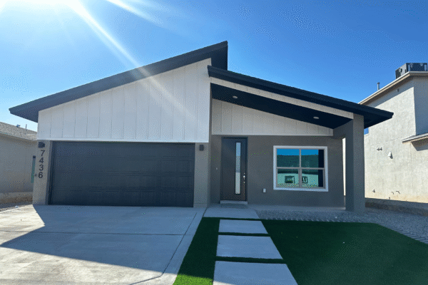 Modern single‑story home exterior with sloped roof and driveway