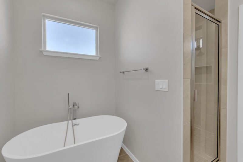 washroom with small size glass bath and large size tub